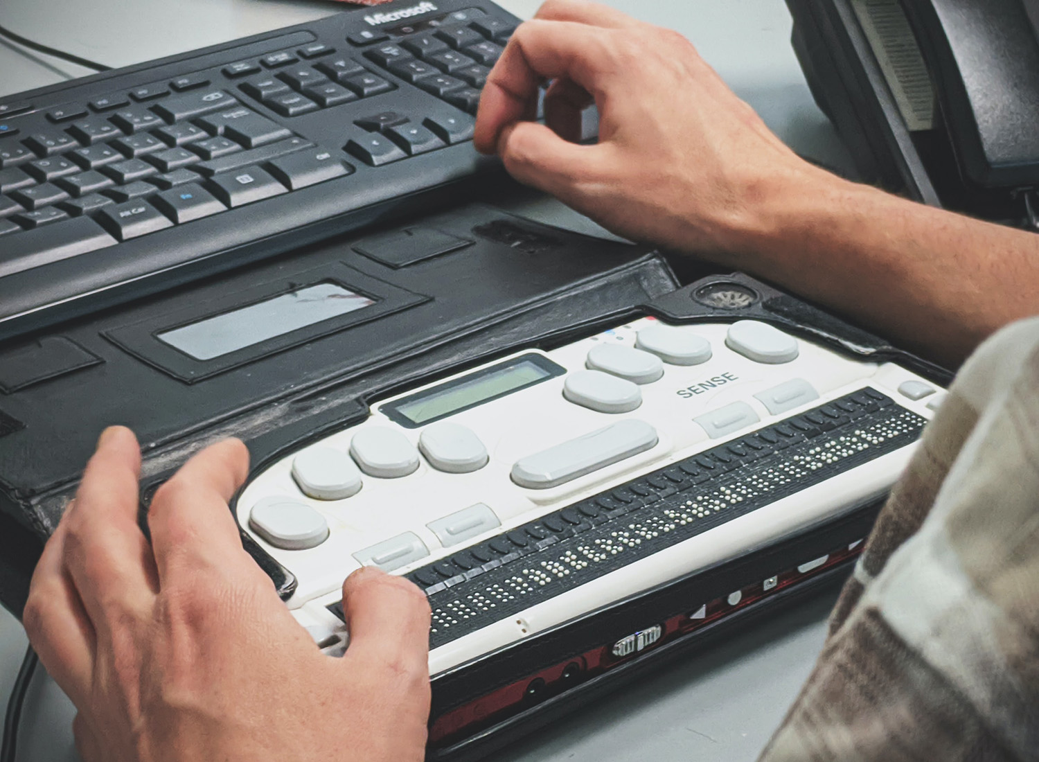Man using a braille screen reading device