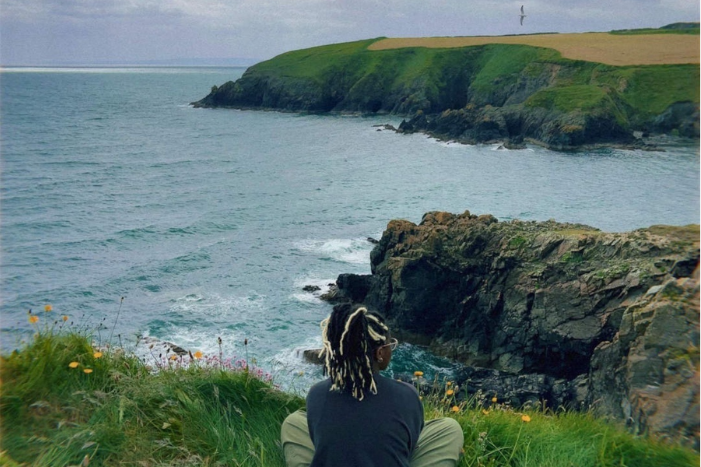 women standing on edge of a cliff looking into the distance