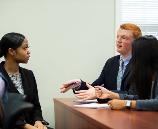 Students in business attire having a discussion