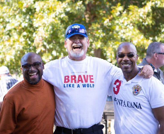 Three men smiling together outside