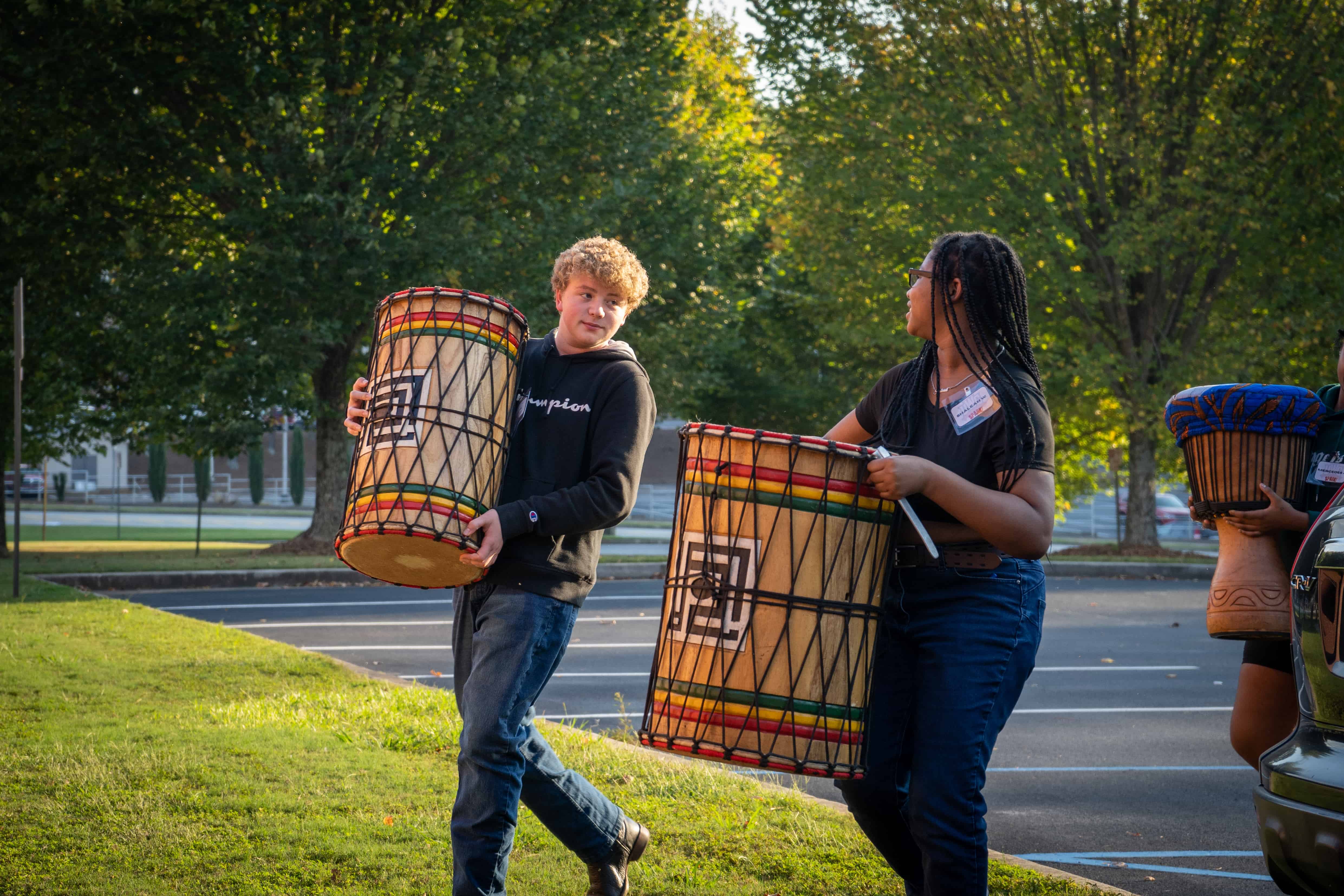 Group of students walking on with a drum.