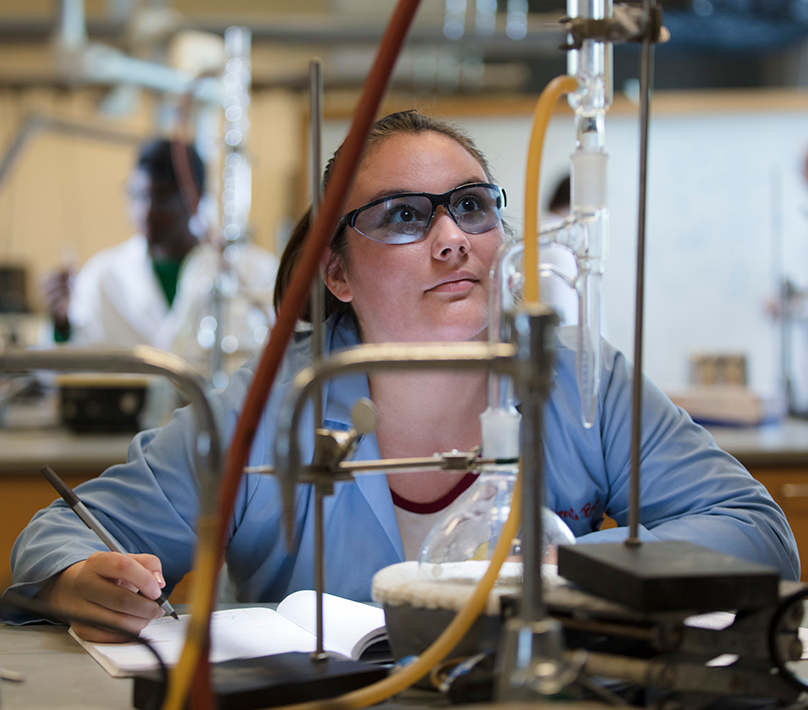 Female UWG student performing a chemical experiment.