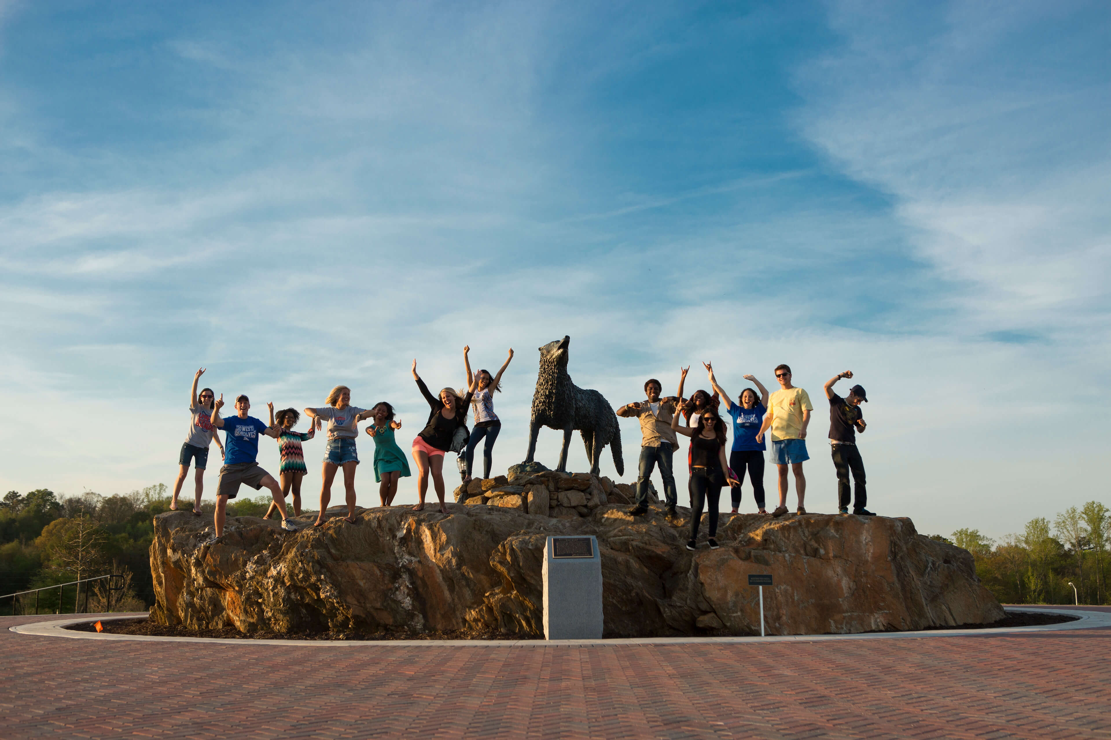 Students next to wolf statue