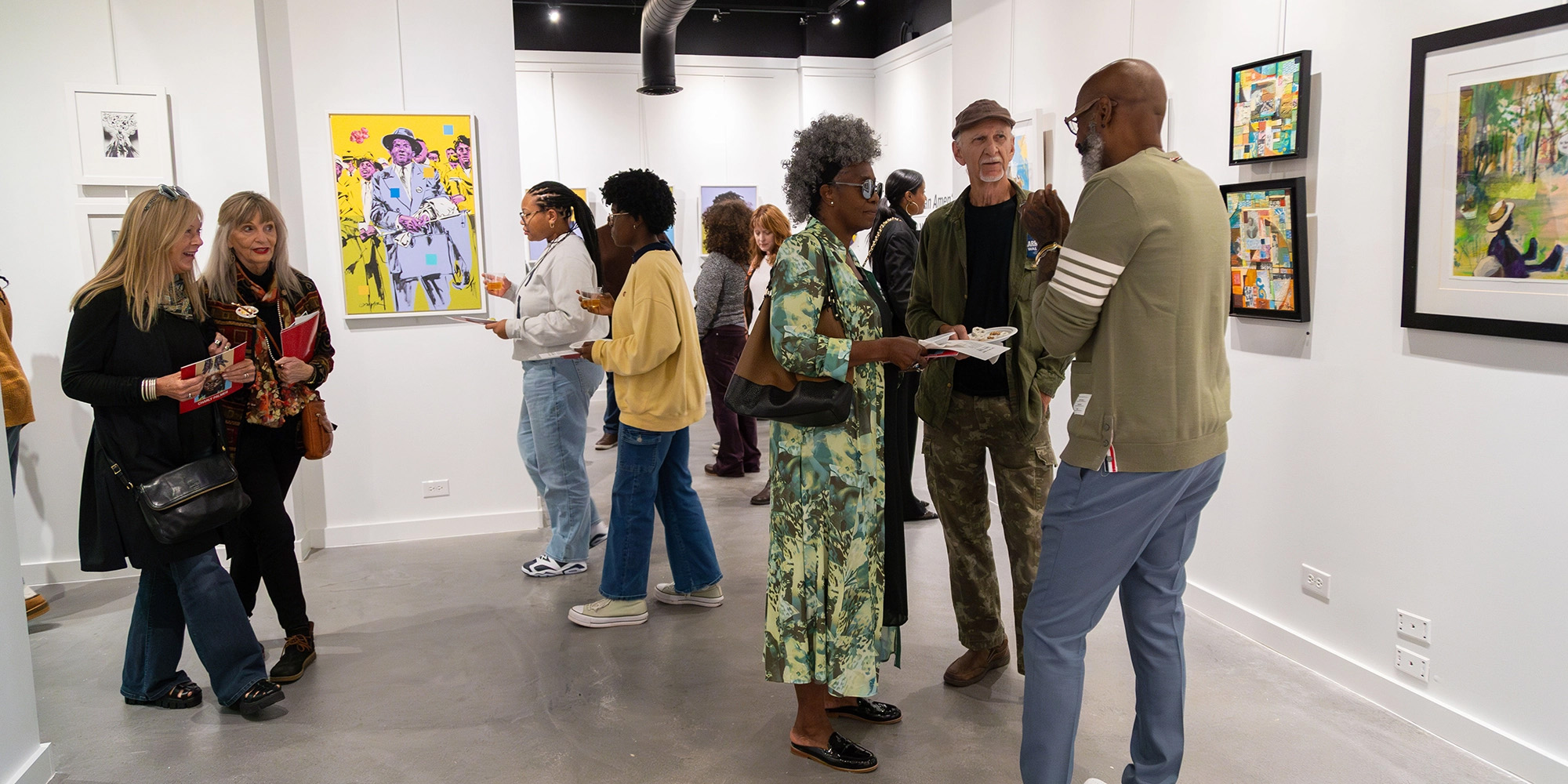 The Vault Gallery exhibition with people looking at art and socializing