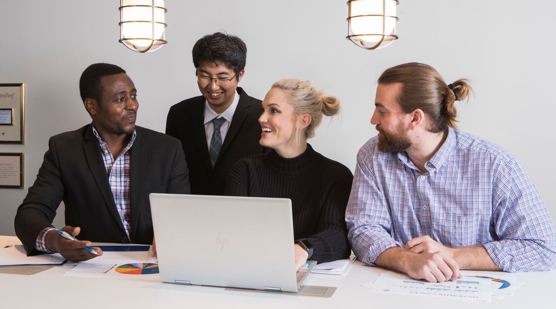 Four students gathered around a computer
