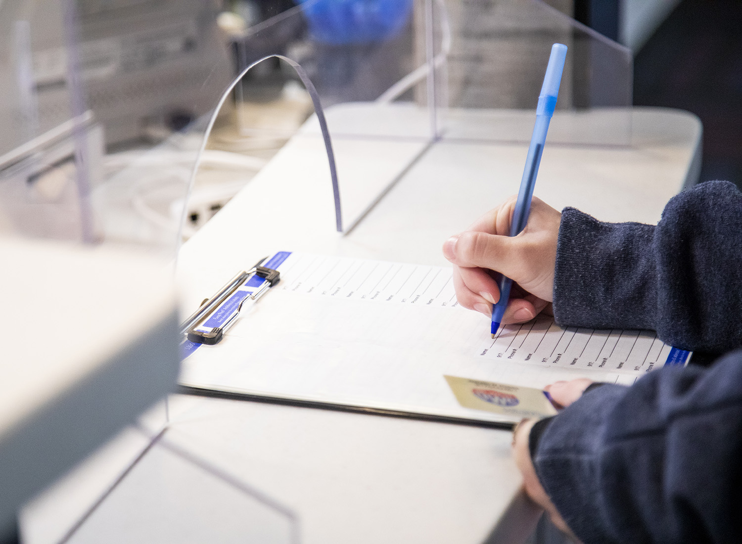 Student filling out paperwork at the Health Services desk