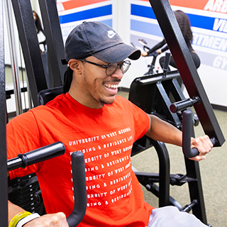 Student doing an arm workout on a machine. 