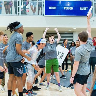 A group of students cheering at an on-campus event. 