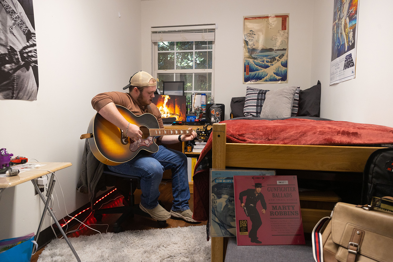 student playing guitar in room