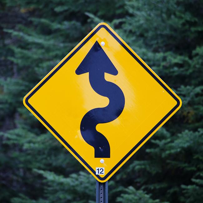 Photograph of a sign indicating a winding road ahead