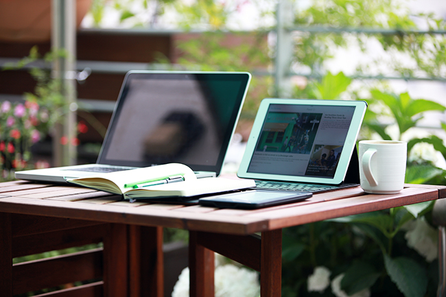 Photograph of a laptop and tablet sitting on a table