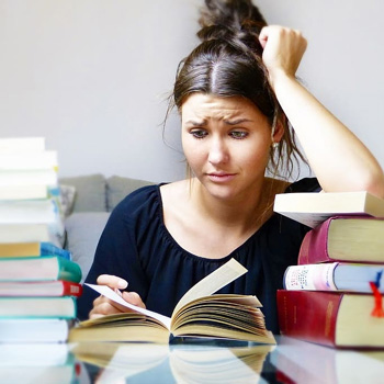 Photograph of a person with a confused expression staring at an open book