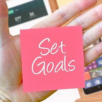Photograph of a sticky note with the words set goals written on it