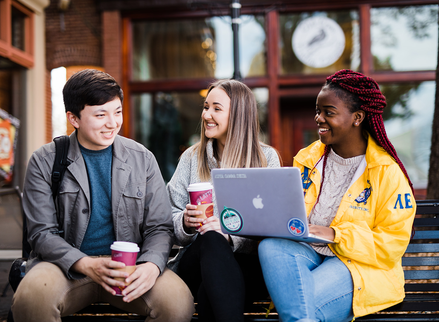 Students sitting outside studying with coffee on the Carrollton square.