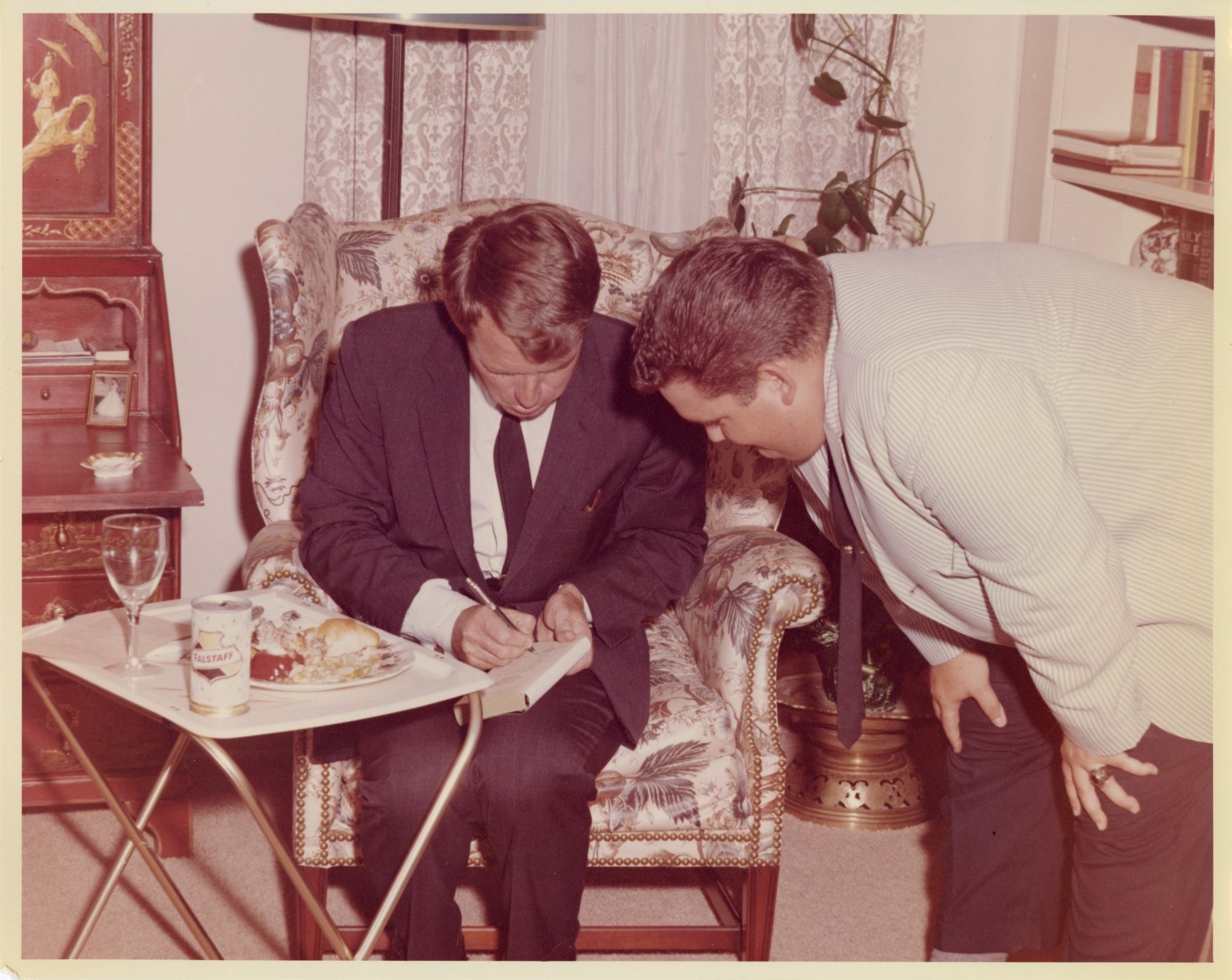Robert Kennedy signing an autograph for a man