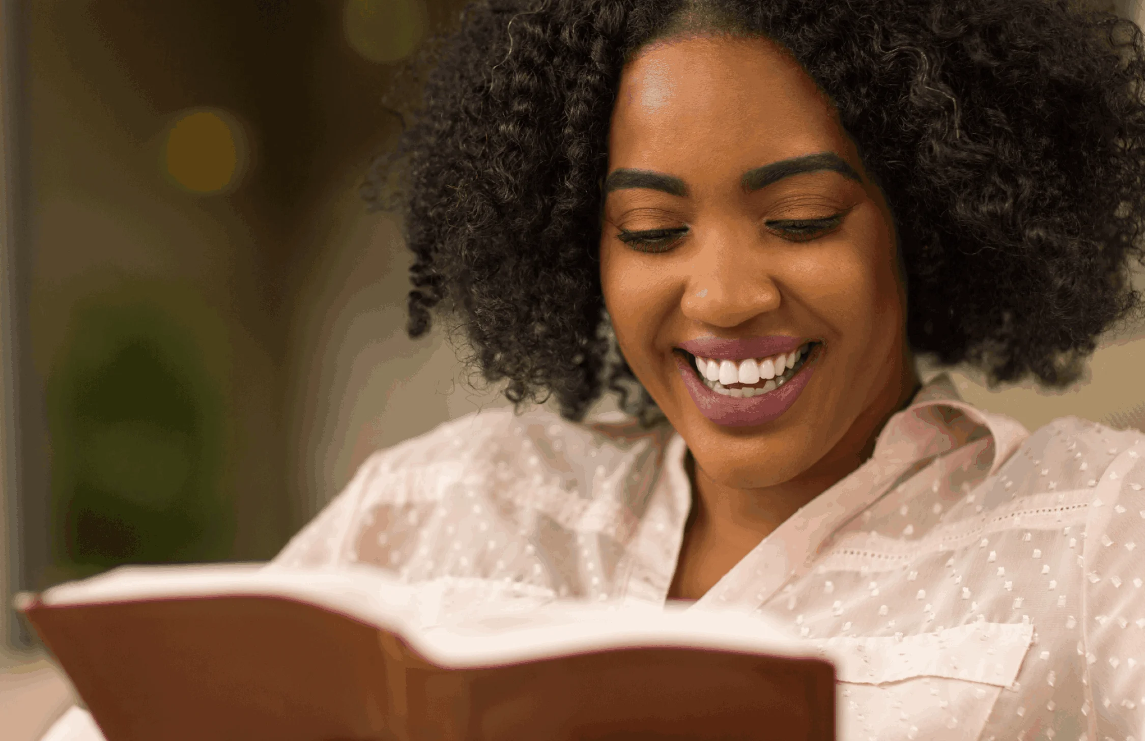 Student reading a book and smiling.