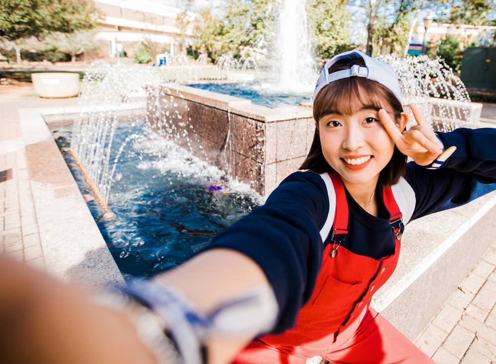 UWG student posing by fountain. 