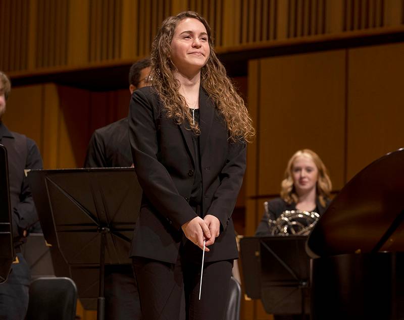 student directing orchestra