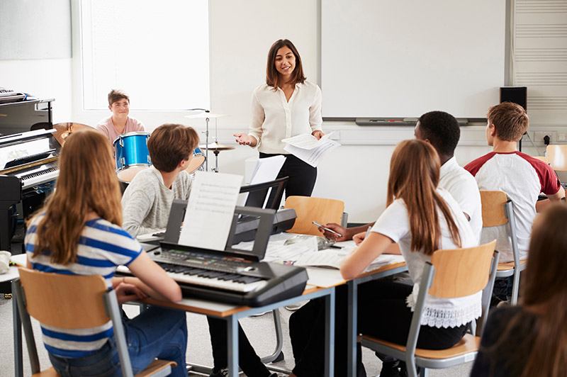 female teacher in classroom teaching students