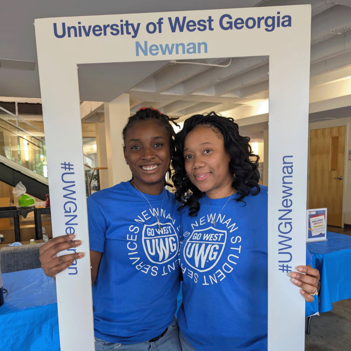 Netasha Russell and TaShaiyah posing in a frame that says "UWG Newnan, Go West, Go Newnan"