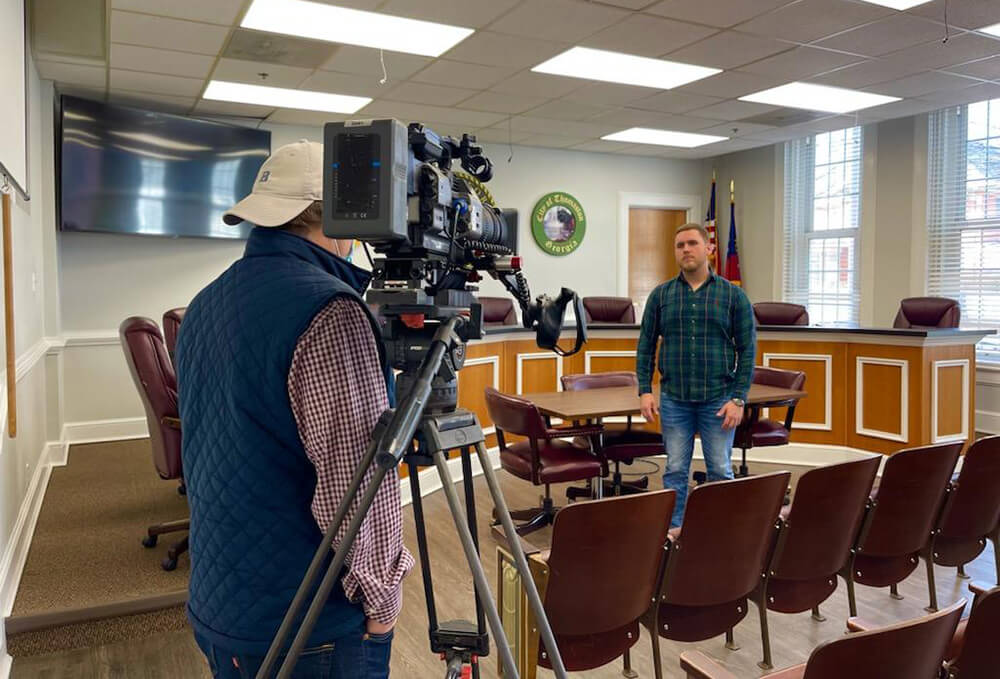 Cameraman with cameras filming Taylor Smith