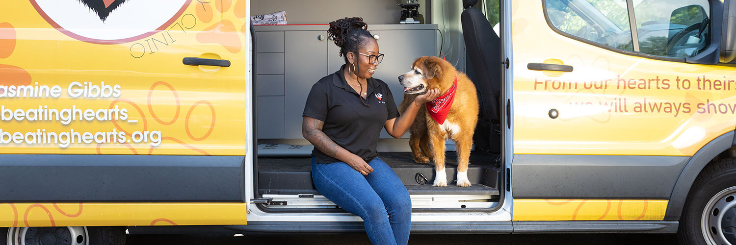 Dr. Jasmine Gibbs and her dog, Spike, outside the Two Beating Hearts Mobile Veterinary Clinic