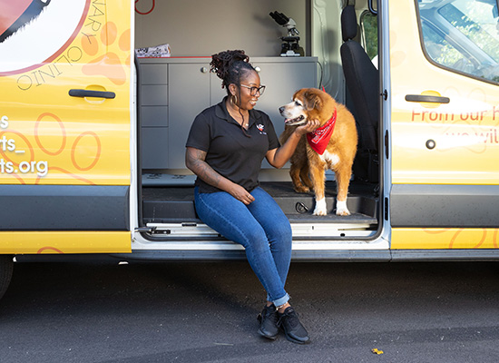 Dr. Jasmine Gibbs and her dog, Spike, outside the Two Beating Hearts Mobile Veterinary Clinic
