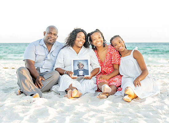 The McDaniel family holds a picture of son Chase on the beach.