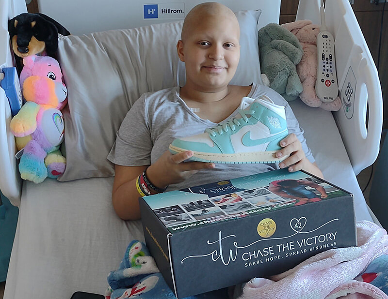 Childhood cancer warrior Stella and her new sneakers from Chase the Victory.