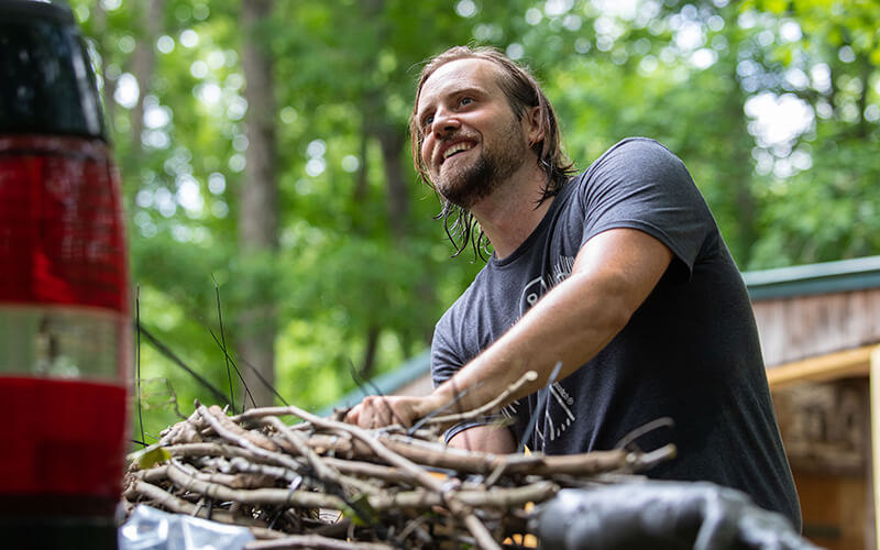 Jesse Duke gathers vines for his third Bigfoot sculpture