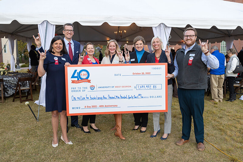 Members of UWG administration and staff hold a giant check