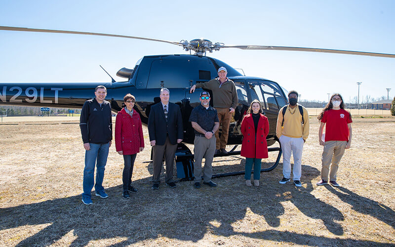 UWG faculty and students in front of a helicopter