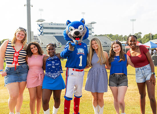 UWG students outside on campus with Wolfie