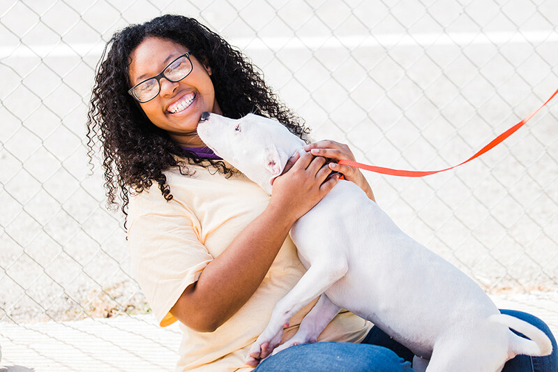 Laughing student holding a cute dog