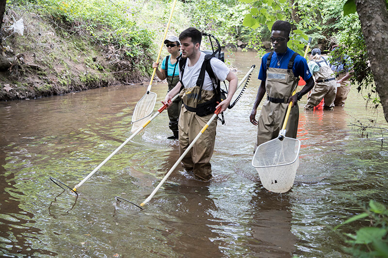 students conducting a river cleanup