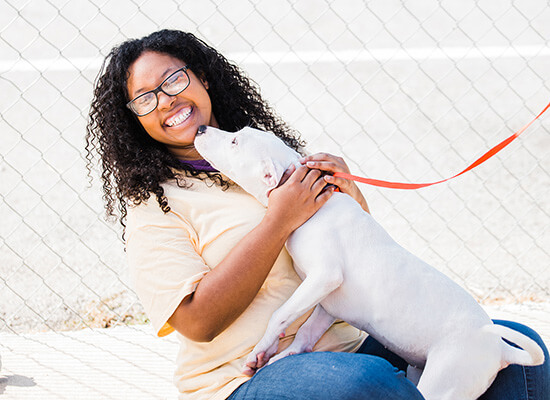 a laughing student holding a cute dog