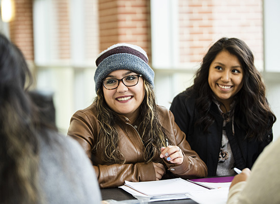 Smiling students sitting around a table