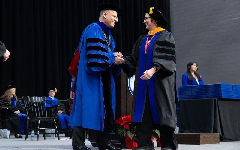 Dr. Michael Johnson, UWG president, congratulates a graduate at commencement