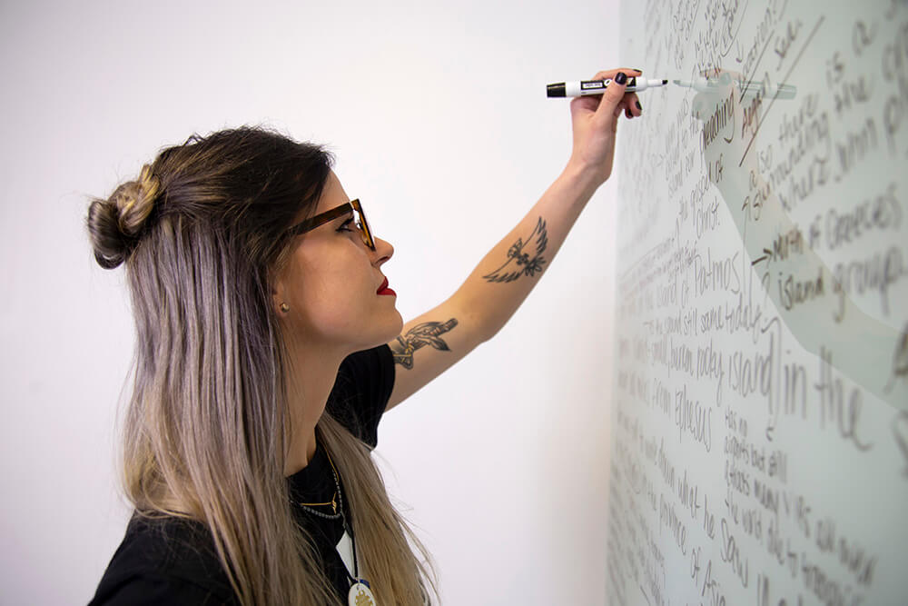 A UWG student writing on a whiteboard
