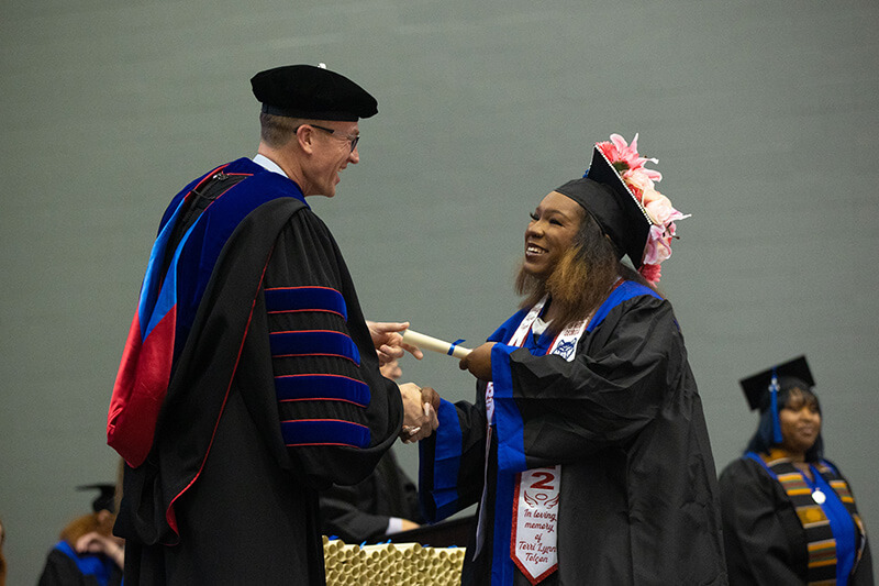 Dr. Kelly congratulates a graduating senior at commencement