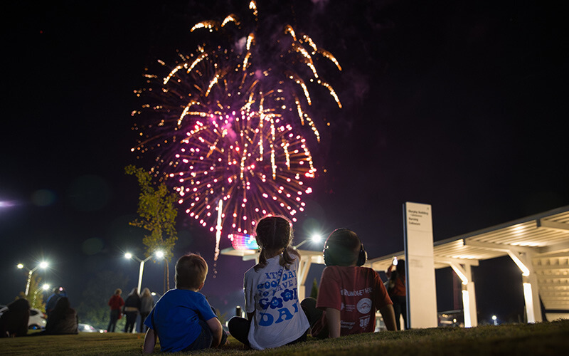 Children watch Homecoming fireworks at night on UWG's campus
