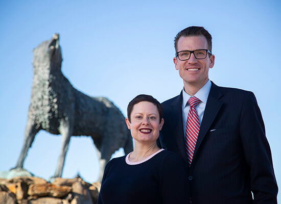 Drs. Brendan and Tressa Kelly stand in front of Wolf statue
