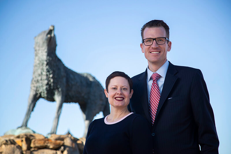 Brendan and Tressa Kelly stand in front of Wolf statue