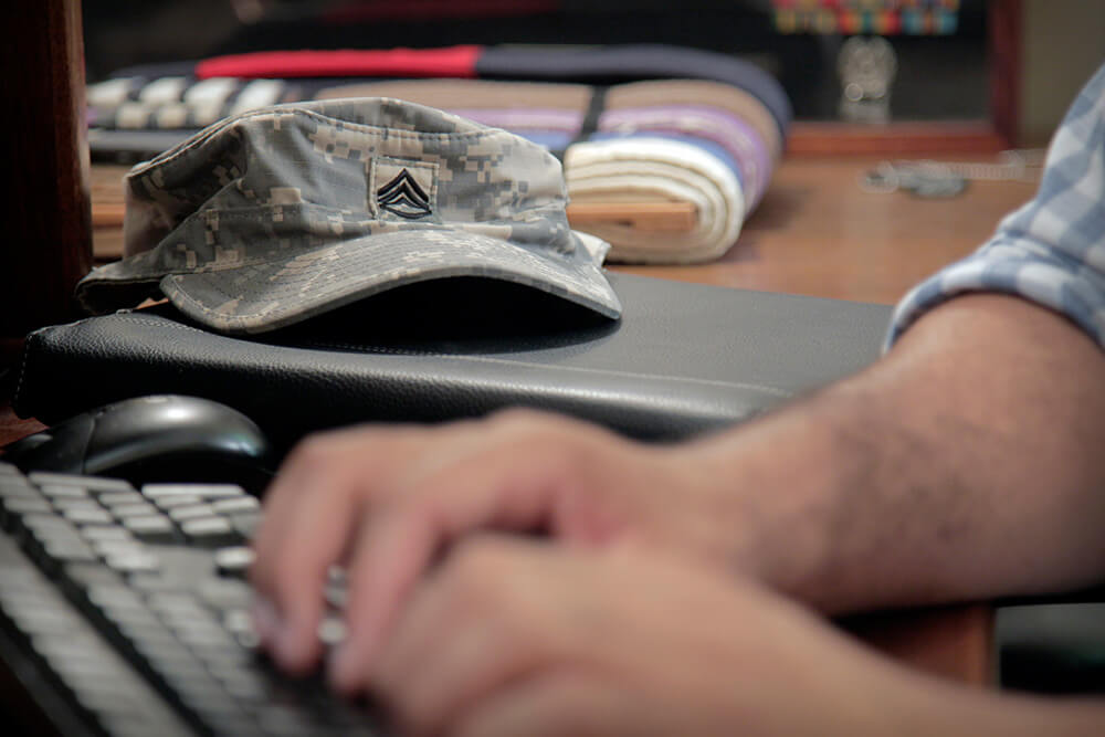 A member of the military types on a computer