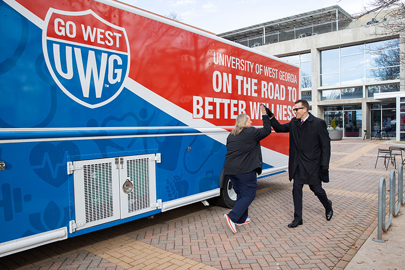 Dr. Brendan Kelly high-fives Bridgette Stewart in front of UWG's mobile health unit