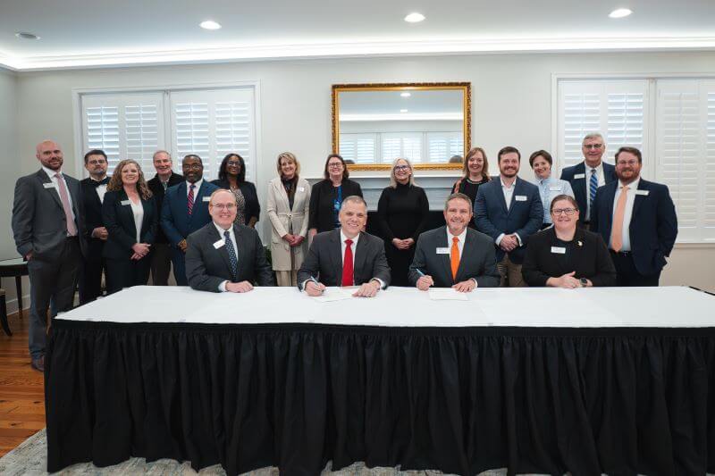 Dr. Michael Johnson, UWG president, and Dr. Mike Hobbs, GHC president, signed the agreement surrounded by leaders from both institutions.