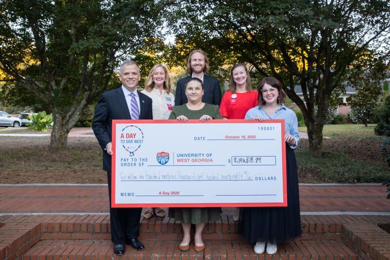 UWG administration celebrate A Day holding a check