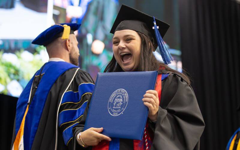 UWG graduate holding her degree celebrates at Spring Commencement 