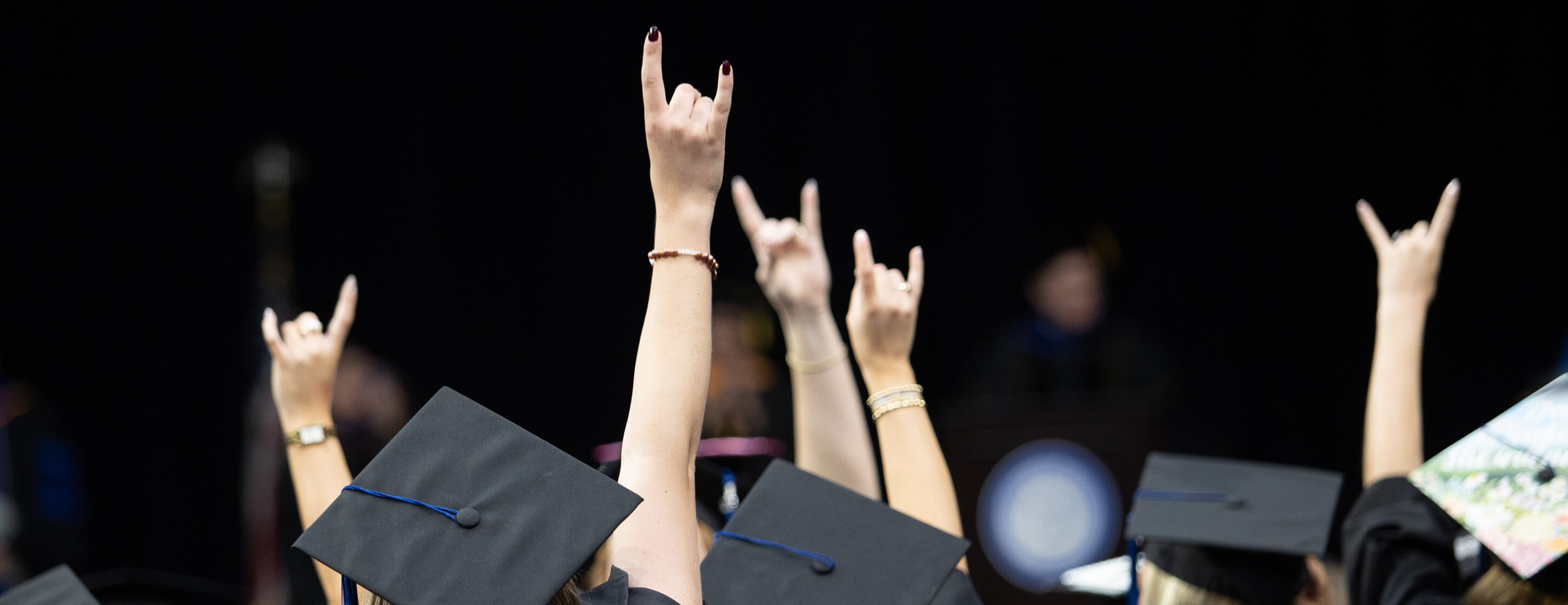 UWG graduates at Spring Commencement give the "Wolves Up" hand sign