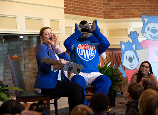 Dr. Tressa Kelly and Wolfie read to a group of school children. 